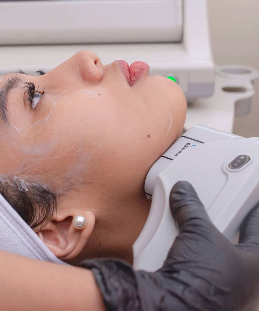 A young woman undergoing HIFU treatment for her jawline. High Intensity Focused Ultrasound technology. At a skin care, dermatologist or aesthetic clinic.